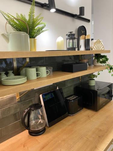 a kitchen with wooden shelves with pots and pans at BRAND NEW Design studio Emerald - old town A/C in Bratislava