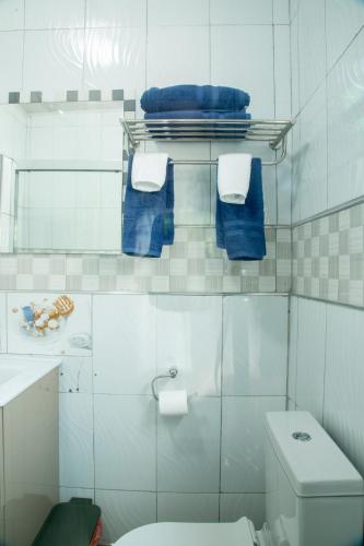 a bathroom with a white toilet and blue towels at Hillview Elegant Residential Suites in Chilenje