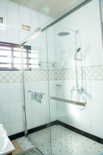 a shower with a glass door in a bathroom at Hillview Elegant Residential Suites in Chilenje