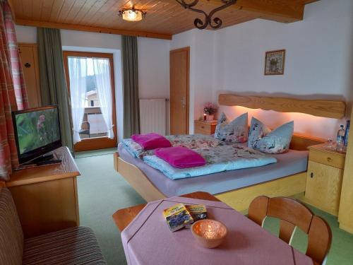a bedroom with a bed and a tv in it at Leyererhof in Ramsau