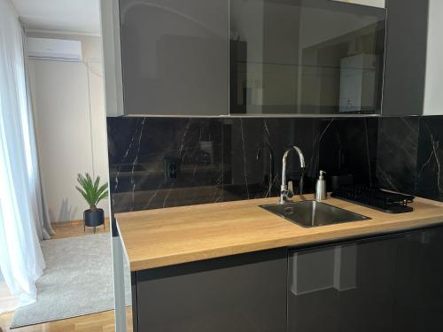 a kitchen counter with a sink and a mirror at PARK LUX II in Vršac