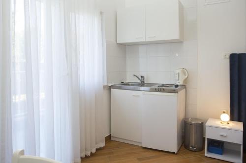 a small kitchen with a sink and a window at Guest House Kušeta in Split