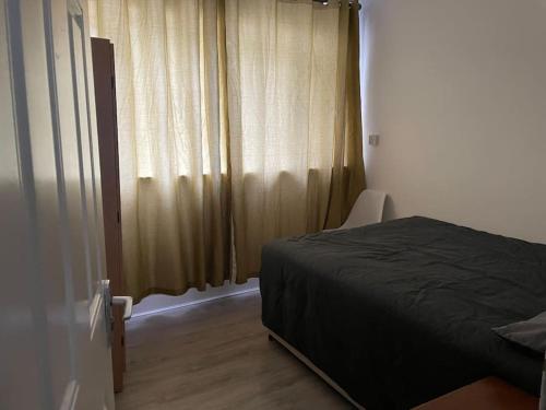 1 dormitorio con 1 cama y una ventana con cortinas en Entire Private House in the Heart of London en Londres
