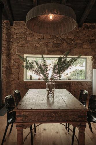 a table with a vase on it with a plant on it at Bode Country House in Monsanto