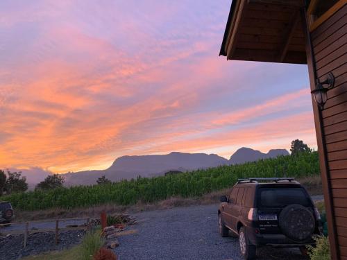 a suv parked outside of a house with a sunset at Refúgio da Montanha Brasil Loft & Panoramic View in Alfredo Wagner