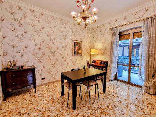ein Esszimmer mit einem Tisch und einem Kronleuchter in der Unterkunft Grazia Guesthouse in Rom
