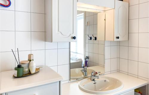 Baño blanco con lavabo y espejo en 4 Bedroom Beautiful Home In Leknes en Leknes