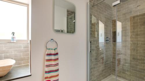 a bathroom with a glass shower and a sink at Pipistrelle Barn in Kniveton
