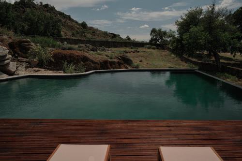 une grande piscine d'eau avec une terrasse en bois dans l'établissement Bode Country House, à Monsanto