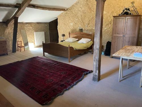 Schlafzimmer mit einem Bett und einem roten Teppich in der Unterkunft Le Fenuac, maison de 4 chambres in Douzillac