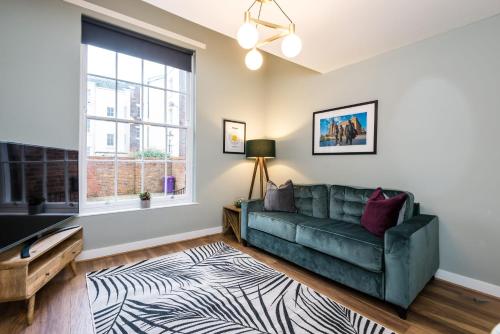 a living room with a green couch and a window at Host & Stay - Canning Quarters in Liverpool