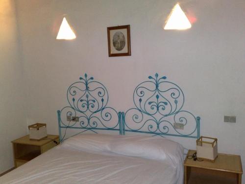 Bett mit blauem Kopfteil in einem Schlafzimmer in der Unterkunft Apartment Alba in Porto Cervo
