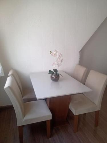 a white table with two chairs and a vase on it at Apartamento para Temporada, sem vaga de garagem! in Belo Horizonte