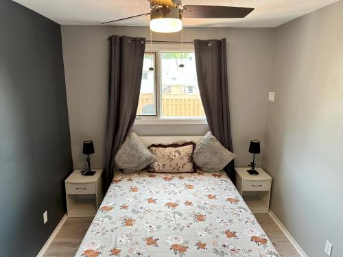 um quarto com uma cama com duas mesas de cabeceira e uma janela em CastleRooms Homestay em Ottawa