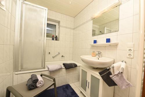 La salle de bains blanche est pourvue d'un lavabo et d'une douche. dans l'établissement Ferienwohnung Allgäuer Bergnest, à Fischen im Allgäu