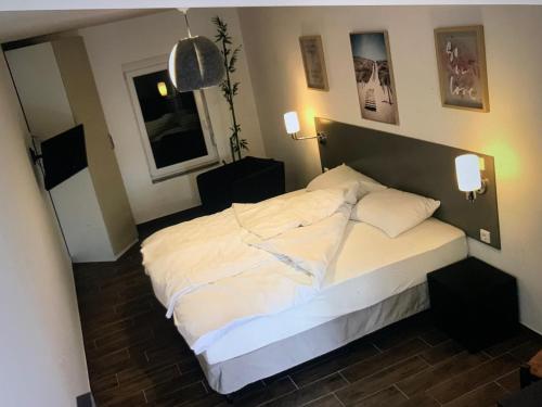 1 dormitorio con 1 cama blanca grande y 2 almohadas en Texas pub & apartman, en Budapest