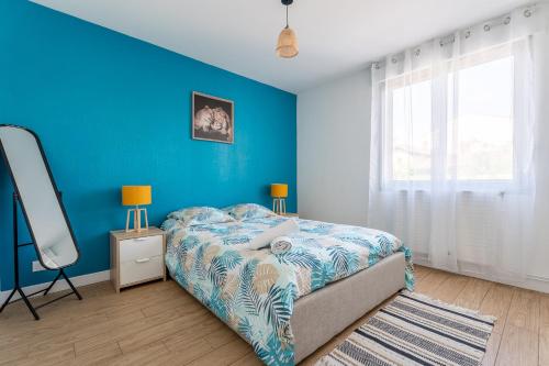 - une chambre bleue avec un lit et un mur bleu dans l'établissement Appartement T2 GDX Privilège - Bourg en Bresse - Centre Ville & Gare, à Bourg-en-Bresse