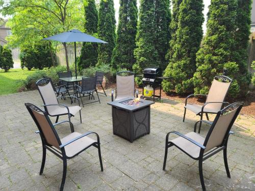 a patio with chairs and a table with a grill at Kitchener Inn & Suites in Kitchener