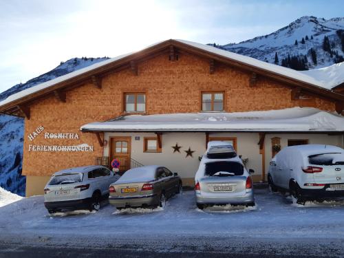 three cars parked in a parking lot in front of a building at Haus Roswitha in Damuls