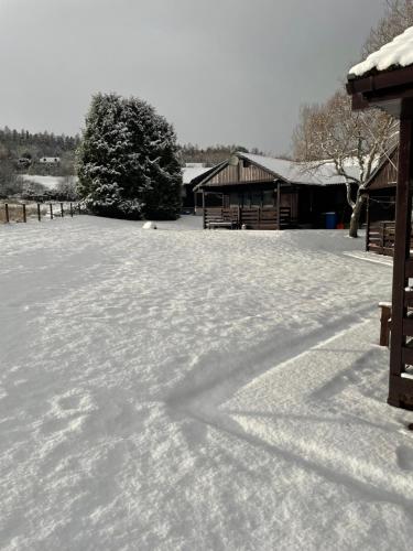 a field covered in snow with a building in the background at Glenview Chalet Park in Inverness