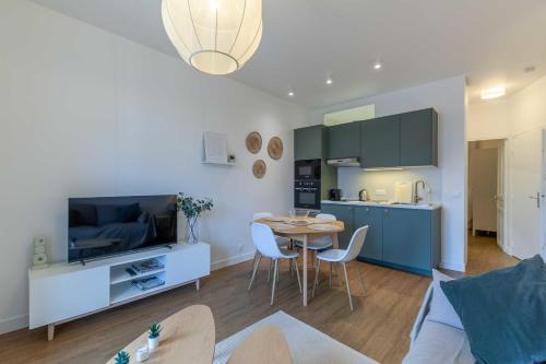une cuisine et un salon avec une table et des chaises dans l'établissement 2-bedroom apartment with balcony near Hippodrome, à Deauville