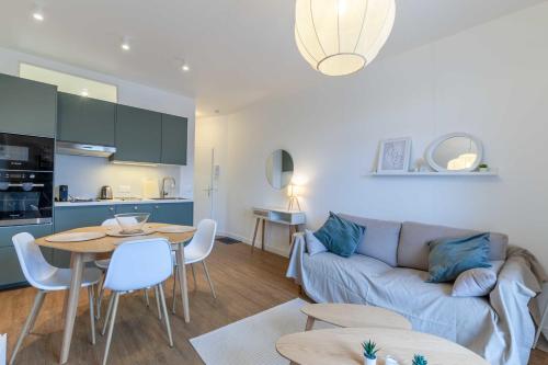un salon avec un canapé et une table dans l'établissement 2-bedroom apartment with balcony near Hippodrome, à Deauville