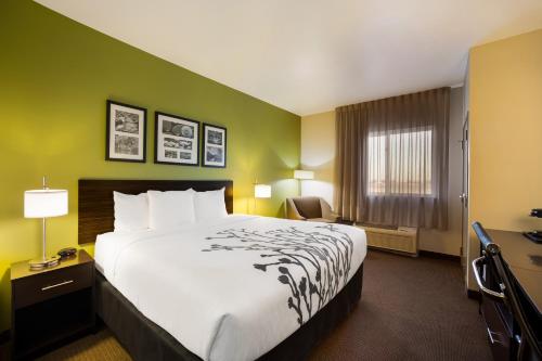 a hotel room with a large bed and a chair at Sleep Inn & Suites in Colby