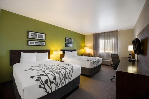 a hotel room with two beds and a television at Sleep Inn & Suites in Colby