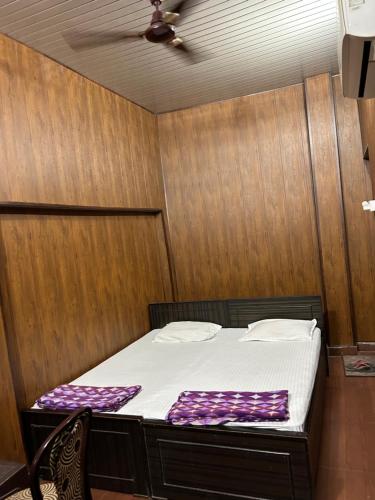 a bed in a room with a wooden wall at SM Guest House in Lucknow