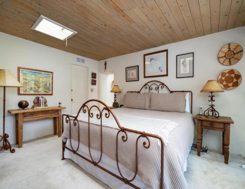 a bedroom with a bed and a wooden ceiling at Harmony House, 3 Bedrooms, 2 wood fireplaces, 3 patios in Santa Fe