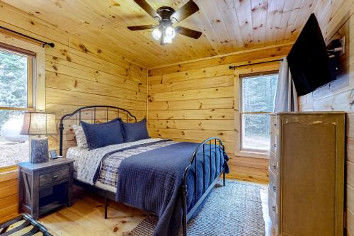 - une chambre avec un lit dans une cabane en rondins dans l'établissement Fishful Thinking, à Cherry Log