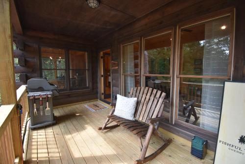 a rocking chair on the porch of a house at Fishful Thinking in Cherry Log