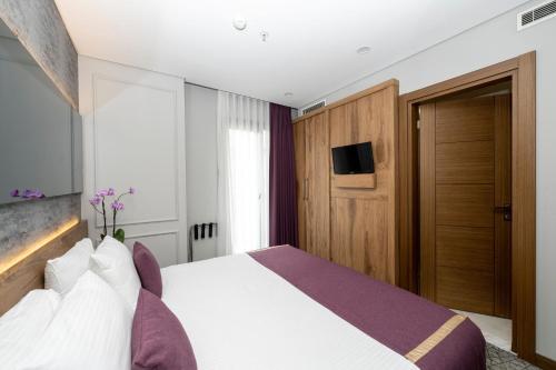 pokój hotelowy z łóżkiem i telewizorem w obiekcie Graziella Gold Hotel w Stambule
