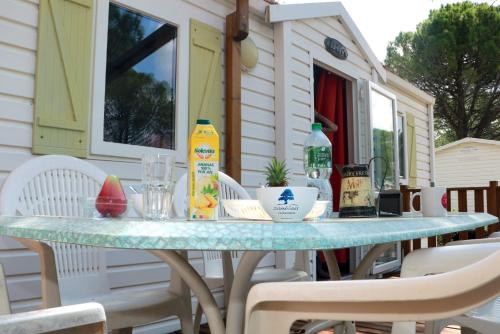 a table on a patio with chairs and drinks on it at Mobilhome «Perle marine»*6 personnes *3 Chambres*TV in Sigean