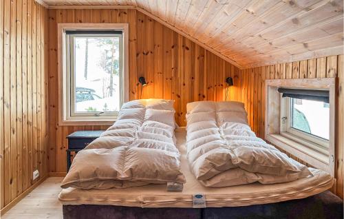 a bed in a room with a wooden wall at Cozy Home In Bykle With Kitchen in Bykle