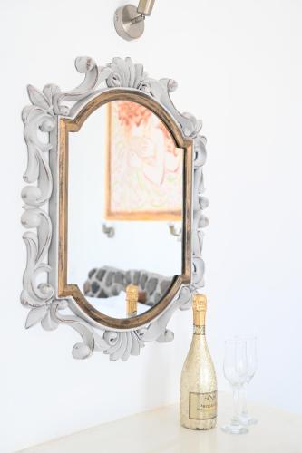 - un miroir sur une table avec une bouteille de vin dans l'établissement Villa Maina, à Kamari