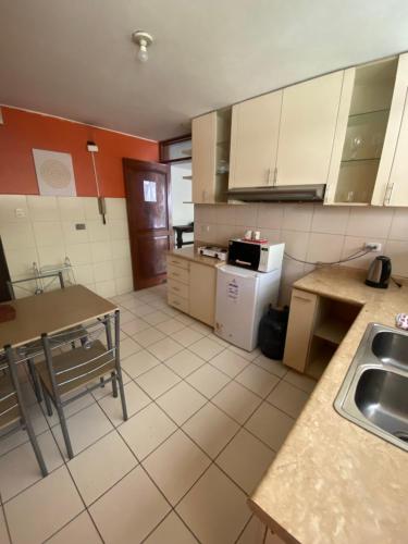 a kitchen with a sink and a table in it at Lima Mini Aparts Monterrico - Cerca Embajada EEUU in Lima