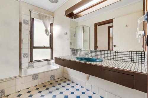 een badkamer met een wastafel, een bad en een spiegel bij Hide Away Paradise in Clyde