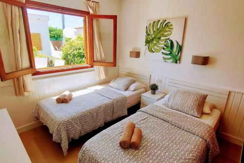 a room with two beds and a window at Precioso Bungalow 4 by CASAS COCODRILO in Playa del Ingles