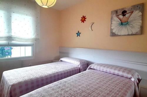 een slaapkamer met 2 bedden en een schilderij aan de muur bij Vistas al mar con jardín privado, piscina y padel in Foz