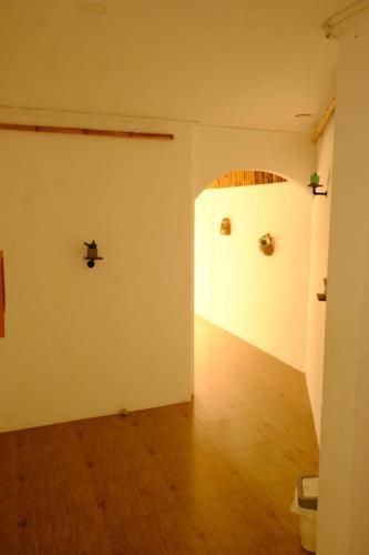 een lege kamer met witte muren en een houten vloer bij Golden Moon Villa in Thongsala
