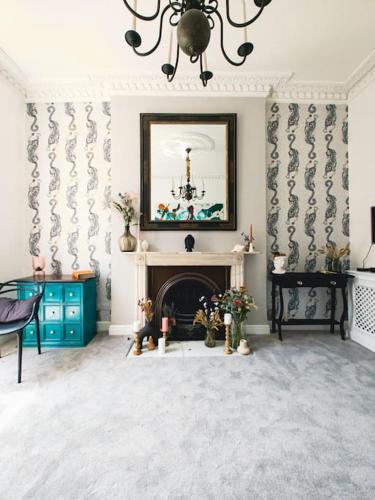 ein Wohnzimmer mit einem Kamin und einem Bild an der Wand in der Unterkunft New Marylebone Gem/One Bedroom in London