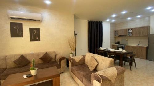 uma sala de estar com um sofá e uma mesa em lacasa chalet private With a panoramic view of the DeadSea em Sowayma