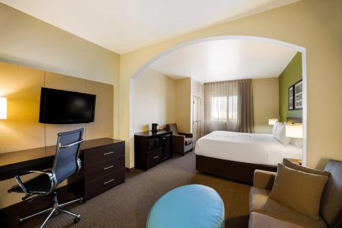 a hotel room with a bed and a desk and chair at Sleep Inn & Suites in Colby
