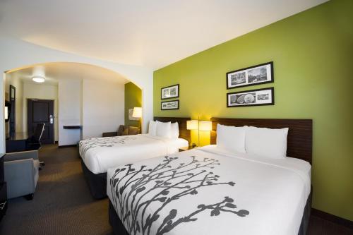 two beds in a hotel room with green walls at Sleep Inn & Suites in Colby