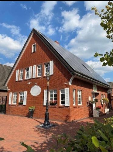 a large red brick house with a black roof at Papenburger Gästehaus in Papenburg