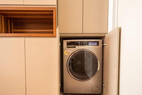 uma máquina de lavar roupa numa cozinha ao lado de um armário em Lüx&central em Istambul