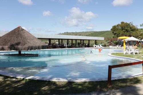 uma piscina com pessoas a brincar na água em Flat na Fazenda Monte Castelo Gravatá Sairé - Mod 12 - Flat 9 em Gravatá