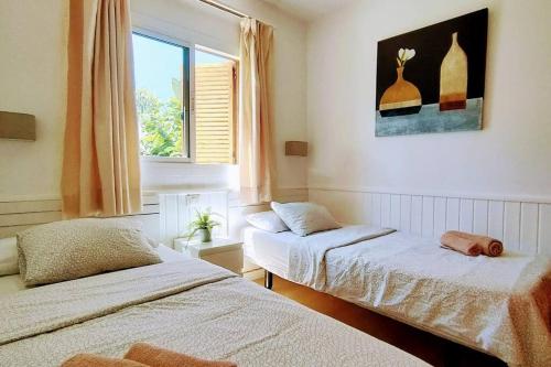 a bedroom with two beds and a window at Precioso Bungalow 12 in Playa del Ingles