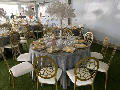 a long table with chairs and plates and wine glasses at Hôtel Freesia in Yaoundé